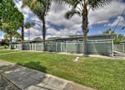 Thumbnail 4 of 24 - A row of green garages are lined up on a sidewalk.