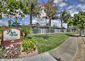 Thumbnail 1 of 24 - A sign for Park West Apartments is in front of a building and trees.