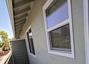 Thumbnail 37 of 42 - A wooden deck with a white window and a grey wall.