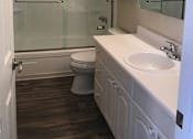 Thumbnail 23 of 30 - A white bathroom with a toilet, sink, and shower.
