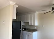 Thumbnail 12 of 62 - a kitchen with a black refrigerator and white cabinets
