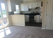 Thumbnail 21 of 26 - an empty kitchen and living room with a carpeted floor