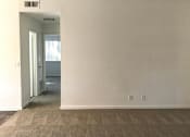 Thumbnail 22 of 26 - A room with a carpeted floor and a doorway leading to another room.