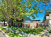 Thumbnail 6 of 44 - A house with a white fence and a tree in front.
