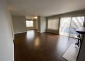 Thumbnail 36 of 41 - an empty living room with wood flooring and sliding glass doors