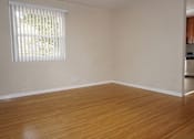 Thumbnail 19 of 22 - A room with wooden floors and a window with blinds.
