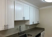 Thumbnail 42 of 62 - a kitchen with white cabinets and a sink