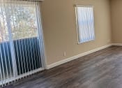 Thumbnail 20 of 36 - an empty living room with a large window and a ceiling fan