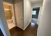 Thumbnail 41 of 41 - a view of a hallway with a door open to a bathroom