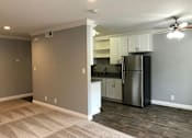 Thumbnail 21 of 43 - A kitchen with a refrigerator, cabinets, and a ceiling fan.