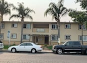 Thumbnail 1 of 14 - two cars parked in front of an apartment building