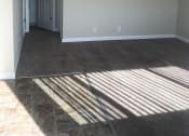 Thumbnail 12 of 31 - an empty living room with sunlight shining on the floor