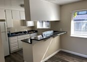 Thumbnail 28 of 43 - A kitchen with a black countertop and white cabinets.