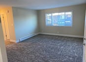 Thumbnail 2 of 43 - A room with a carpeted floor and a window with blinds.