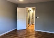 Thumbnail 28 of 47 - A room with a white door and wooden floor.