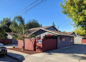 Thumbnail 2 of 36 - a house with a red fence and a tree in front of it