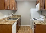 Thumbnail 16 of 22 - A kitchen with white appliances and wooden cabinets.