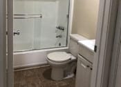 Thumbnail 32 of 33 - A white toilet sits in a bathroom next to a glass shower door.
