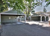 Thumbnail 16 of 31 - A residential area with a garage and a tree.