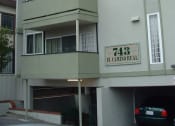 Thumbnail 3 of 10 - an apartment building with a car parked in front of it