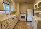 Thumbnail 29 of 38 - A kitchen with white appliances and cabinets.