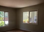 Thumbnail 33 of 38 - A room with wooden floors and two windows.
