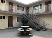 Thumbnail 4 of 14 - an outside view of an apartment building with a table and a staircase