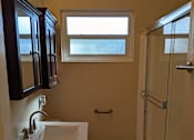 Thumbnail 34 of 42 - A bathroom with a toilet, sink, and shower.