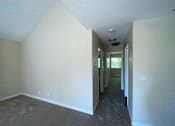 Thumbnail 21 of 26 - A long hallway with a door at the end.