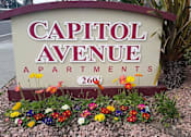 Thumbnail 16 of 33 - A sign for Capitol Avenue Apartments with flowers in front.