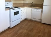 Thumbnail 23 of 36 - a kitchen with white appliances and a wooden floor