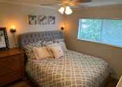 Thumbnail 23 of 32 - a bedroom with a bed and a ceiling fan and a window