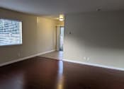 Thumbnail 34 of 36 - A room with wooden floors and a window with blinds.