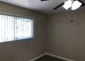 Thumbnail 16 of 62 - a living room with a window and a ceiling fan