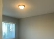 Thumbnail 15 of 37 - A room with a carpeted floor and a window with curtains.