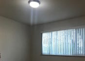 Thumbnail 30 of 37 - A room with a carpeted floor and a window with blinds.
