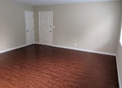 Thumbnail 31 of 36 - A room with two doors and wooden flooring.
