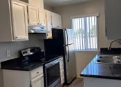 Thumbnail 29 of 51 - a kitchen with a stove refrigerator and sink