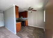 Thumbnail 38 of 51 - a empty kitchen with a ceiling fan and wooden floors
