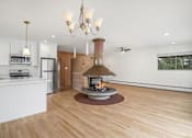 Thumbnail 26 of 33 - A modern kitchen with a wood stove in the middle of the room.