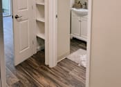 Thumbnail 5 of 16 - a bathroom with an open door and a sink and shelves