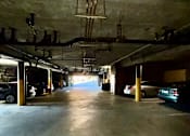 Thumbnail 8 of 8 - A long, narrow parking garage with cars parked on both sides.