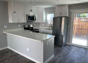 Thumbnail 4 of 19 - A kitchen with a white island and stainless steel appliances.