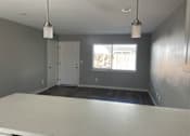 Thumbnail 7 of 19 - A room with a white table and two hanging lights.