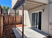 Thumbnail 18 of 19 - A patio area with a concrete floor and a wooden fence.