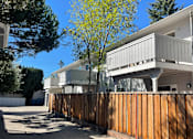 Thumbnail 2 of 19 - A modern house with a wooden fence in front.