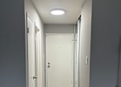 Thumbnail 15 of 18 - A modern kitchen with a white cabinet and a wooden wall.