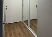Thumbnail 17 of 18 - A white cabinet with two doors is open, revealing a wooden shelf inside.