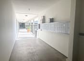 Thumbnail 10 of 23 - A long hallway with a row of lockers on the right side.