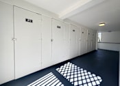 Thumbnail 14 of 23 - A row of white lockers with the first one labeled F1.